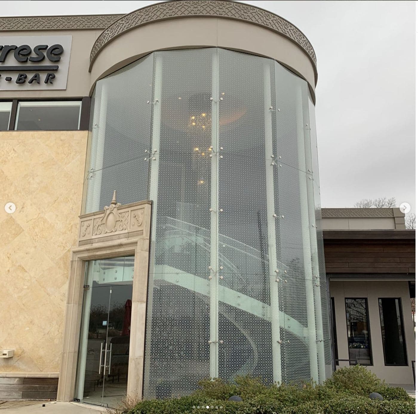 Calabrese three-story curved glass entry with tile-matched pattern